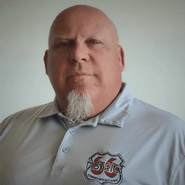 A man with a beard and mustache wearing a white shirt.