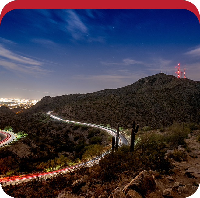 A view of the city lights from atop a hill.